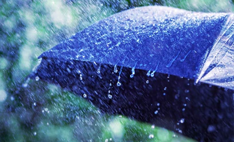 Raining coming down on a blue umbrella.