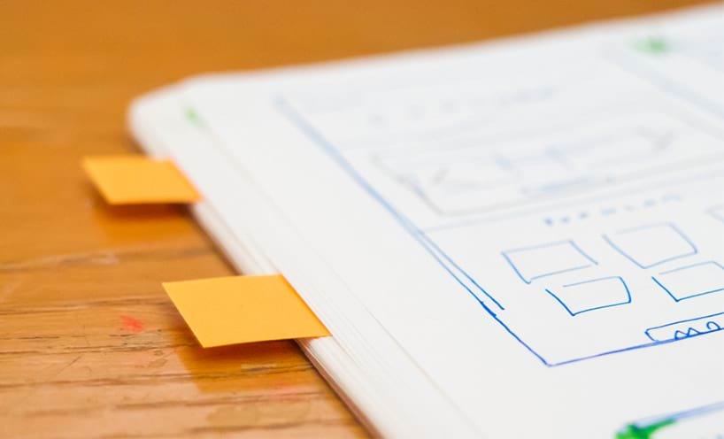 Paperwork on a desk with pages marked.