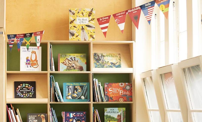Children's books in a school bookshelf with colourful bunting flags